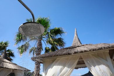 Outdoor shower with running water on beach at resort