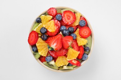 Yummy fruit salad in bowl on white background, top view