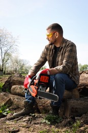 Man with modern saw on sunny day