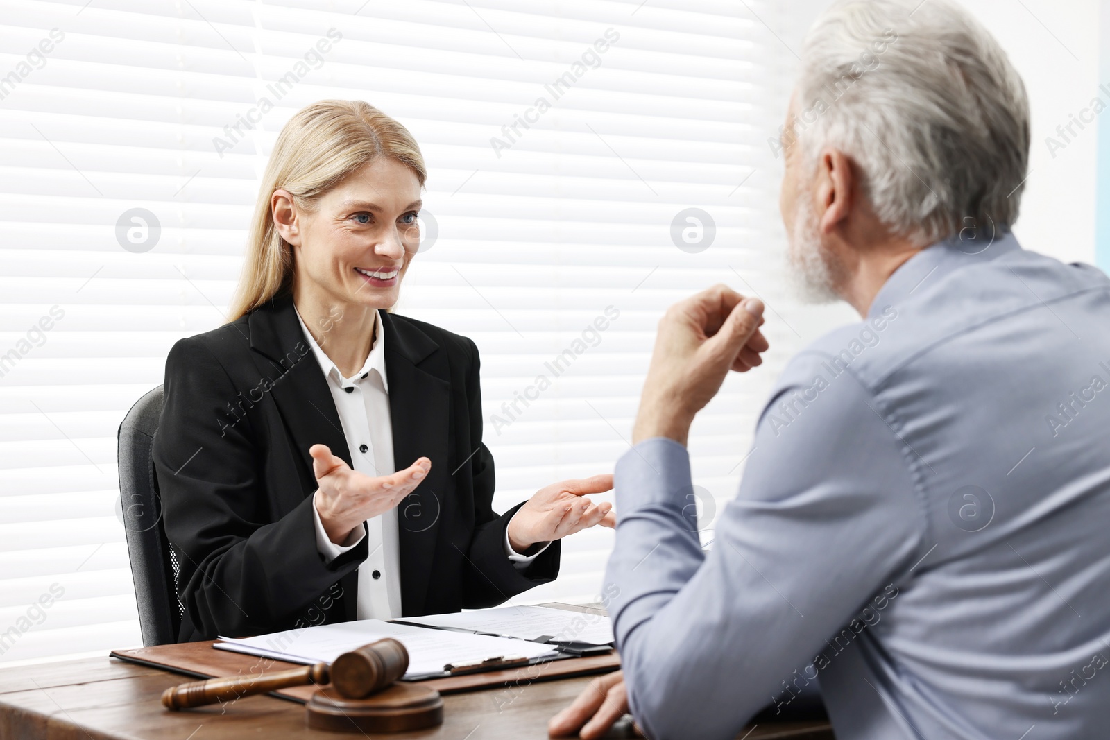 Photo of Senior man having meeting with lawyer in office