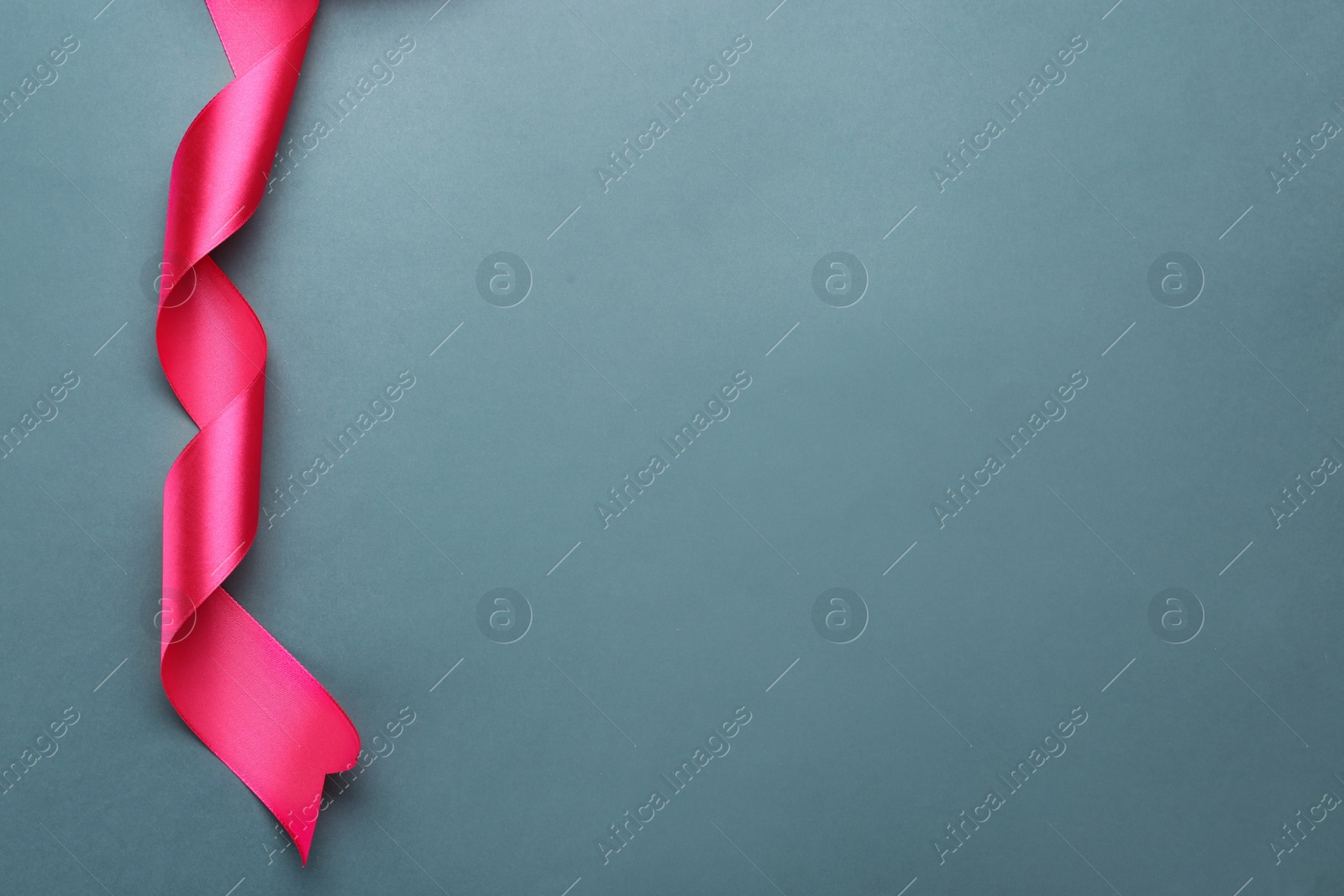 Photo of Beautiful pink ribbon on grey background, top view. Space for text