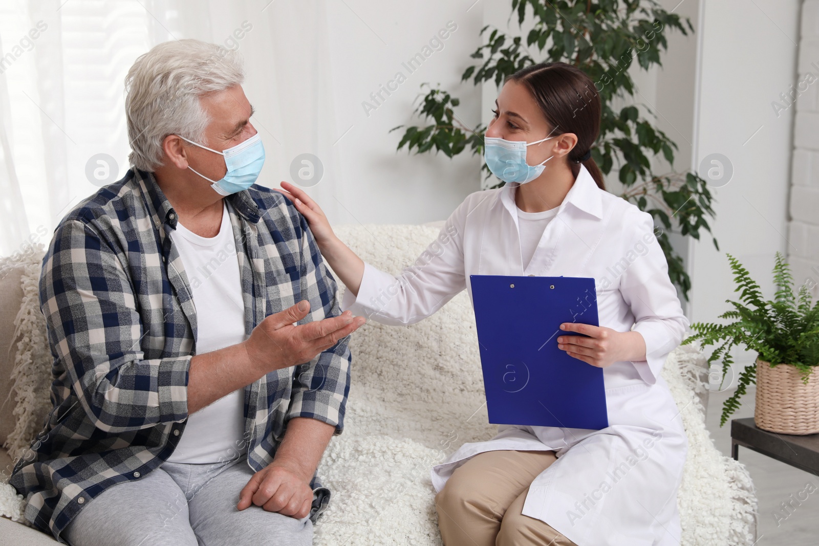 Photo of Doctor examining senior man with protective mask at nursing home