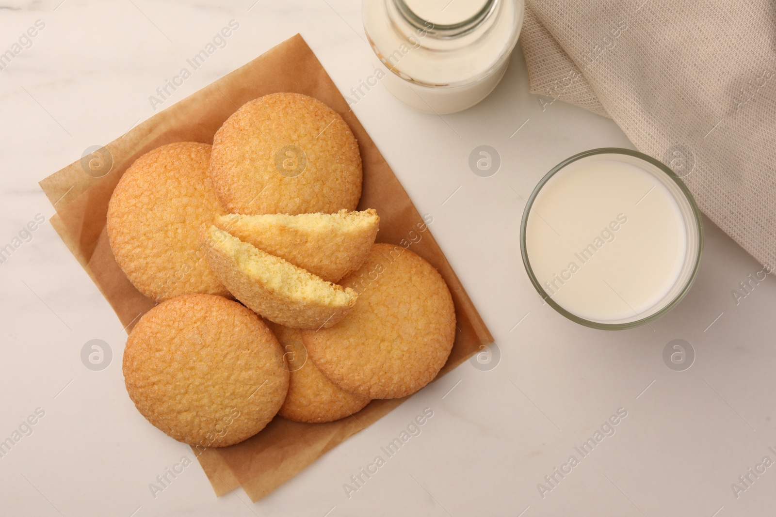 Photo of Delicious Danish butter cookies and milk on white marble table, flat lay