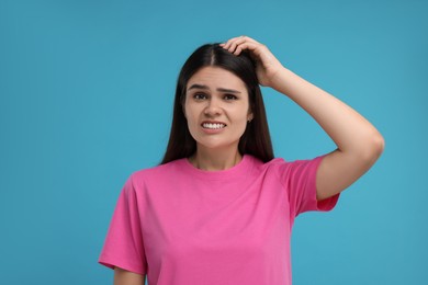 Photo of Embarrassed young woman on light blue background