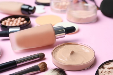 Photo of Composition with skin foundation and beauty accessories on color background