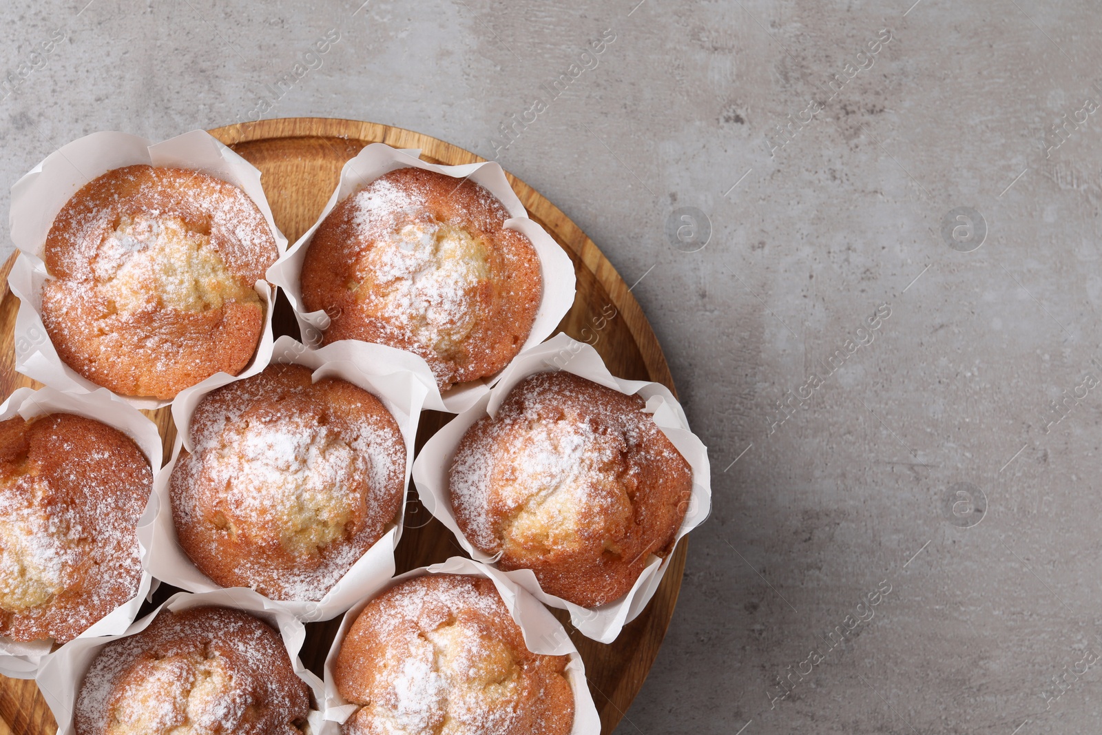 Photo of Delicious muffins on grey table, top view. space for text