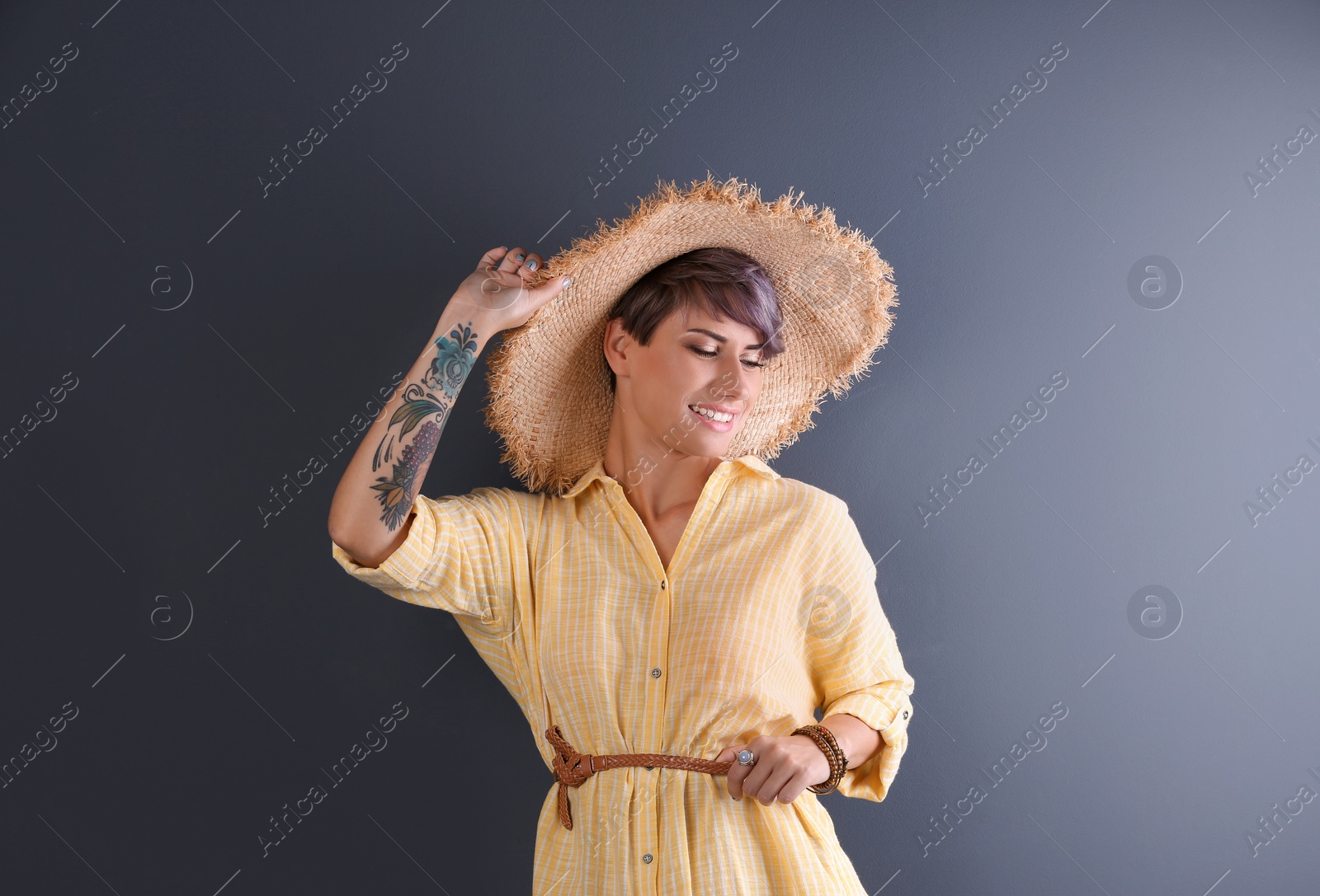 Photo of Trendy young woman with tattoo on color background