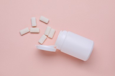 Photo of Jar with chewing gums on light pink background, flat lay