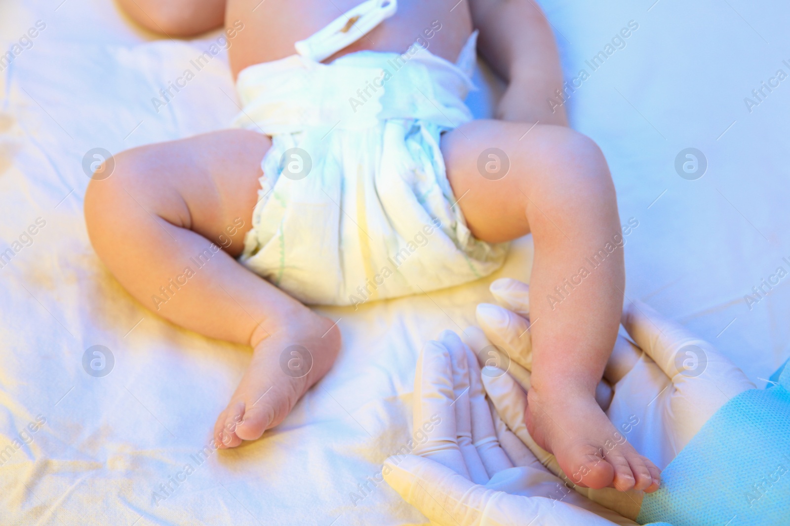 Photo of Doctor holding newborn child's foot in hospital, closeup