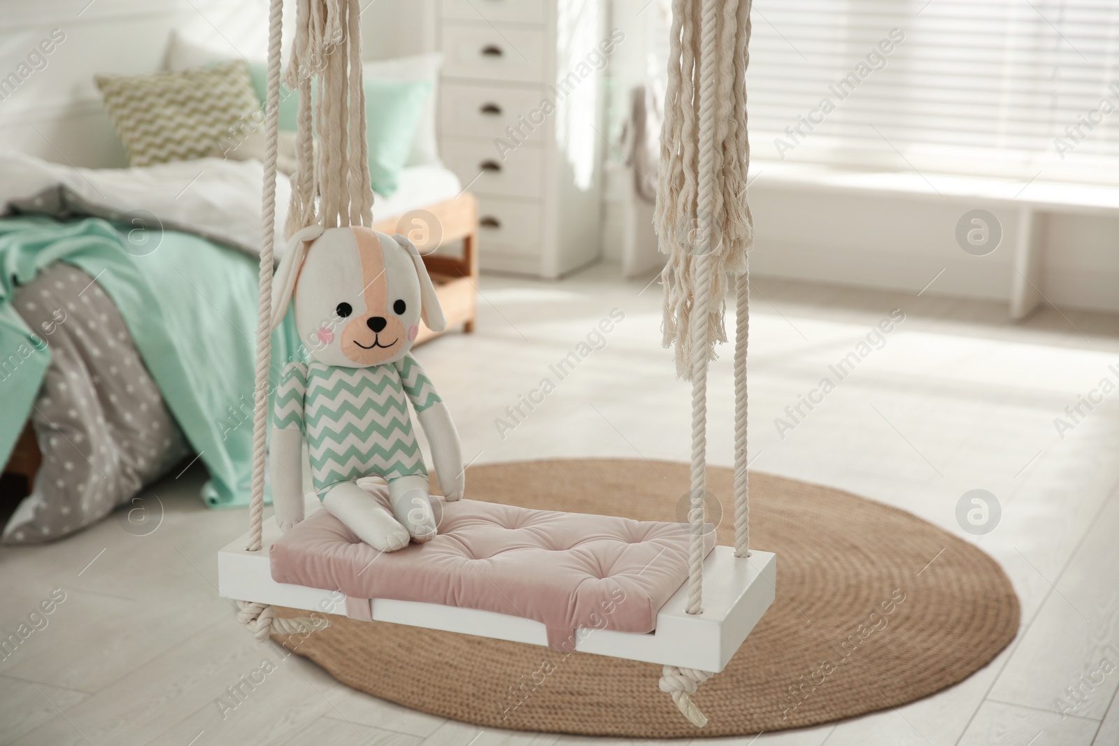 Photo of Stylish swing with toy in child's room. Interior design