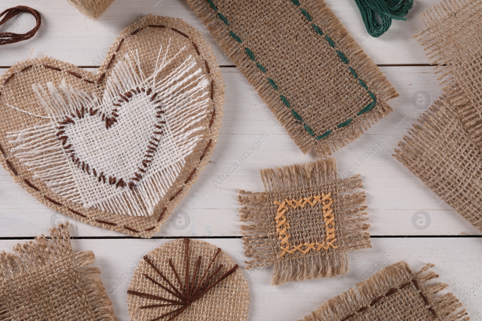 Photo of Flat lay composition with pieces of burlap fabric on white wooden table