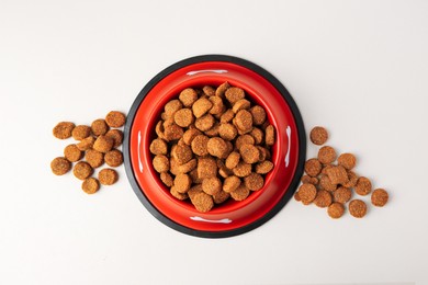 Photo of Dry dog food and feeding bowl on beige background, flat lay