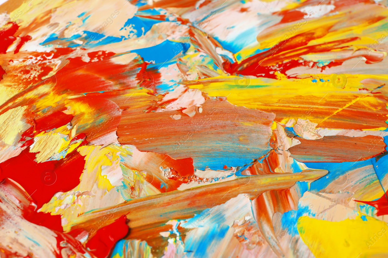 Photo of Closeup view of artist's palette with mixed bright paints as background