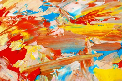 Photo of Closeup view of artist's palette with mixed bright paints as background