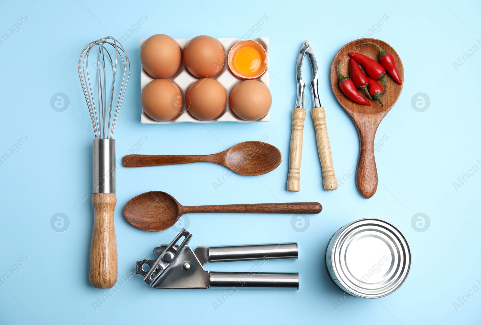 Photo of Cooking utensils and ingredients on light blue background, flat lay