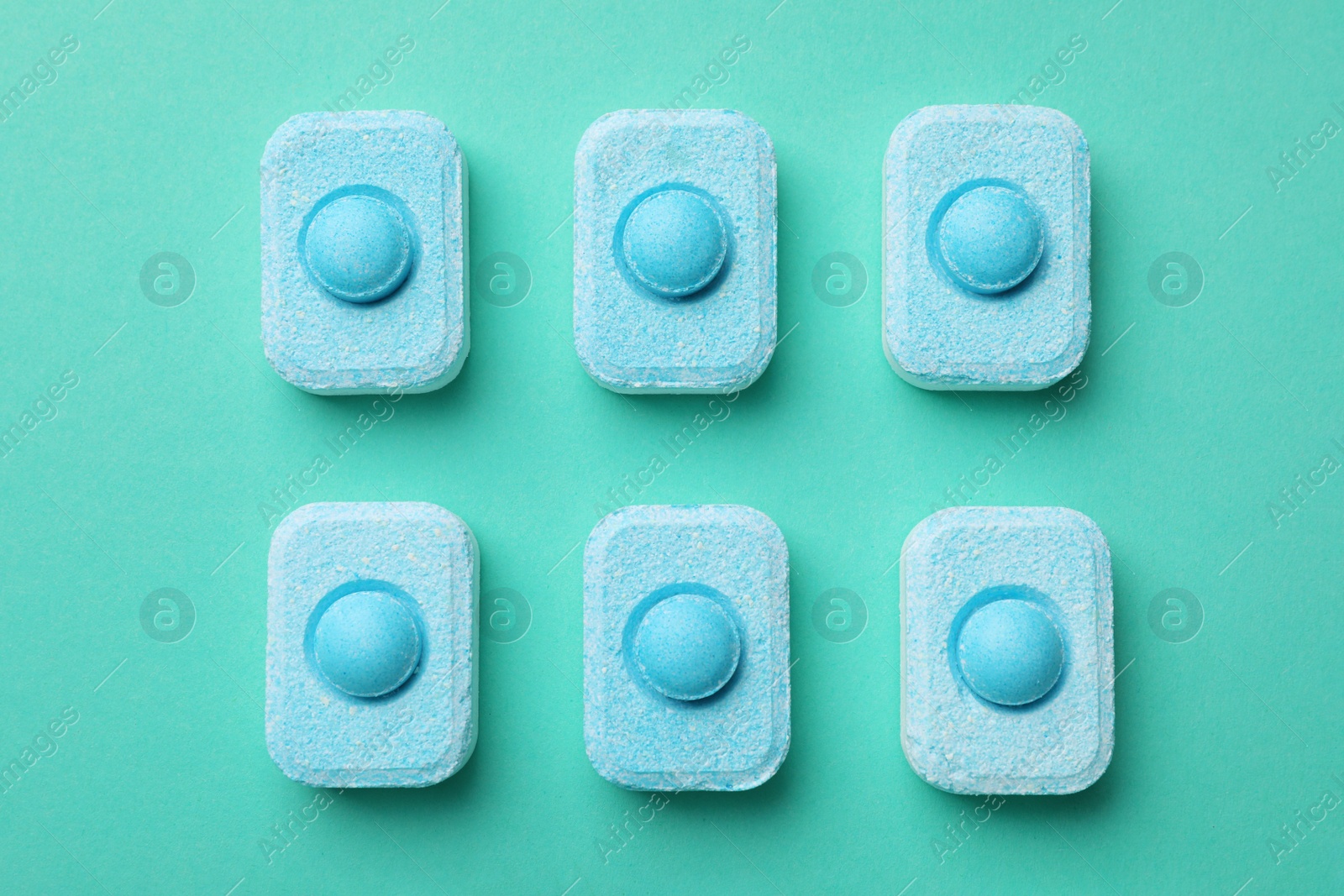 Photo of Water softener tablets on turquoise background, flat lay