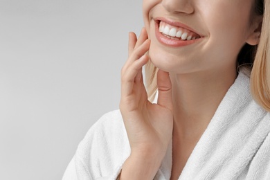 Young woman with silky skin on light background, closeup