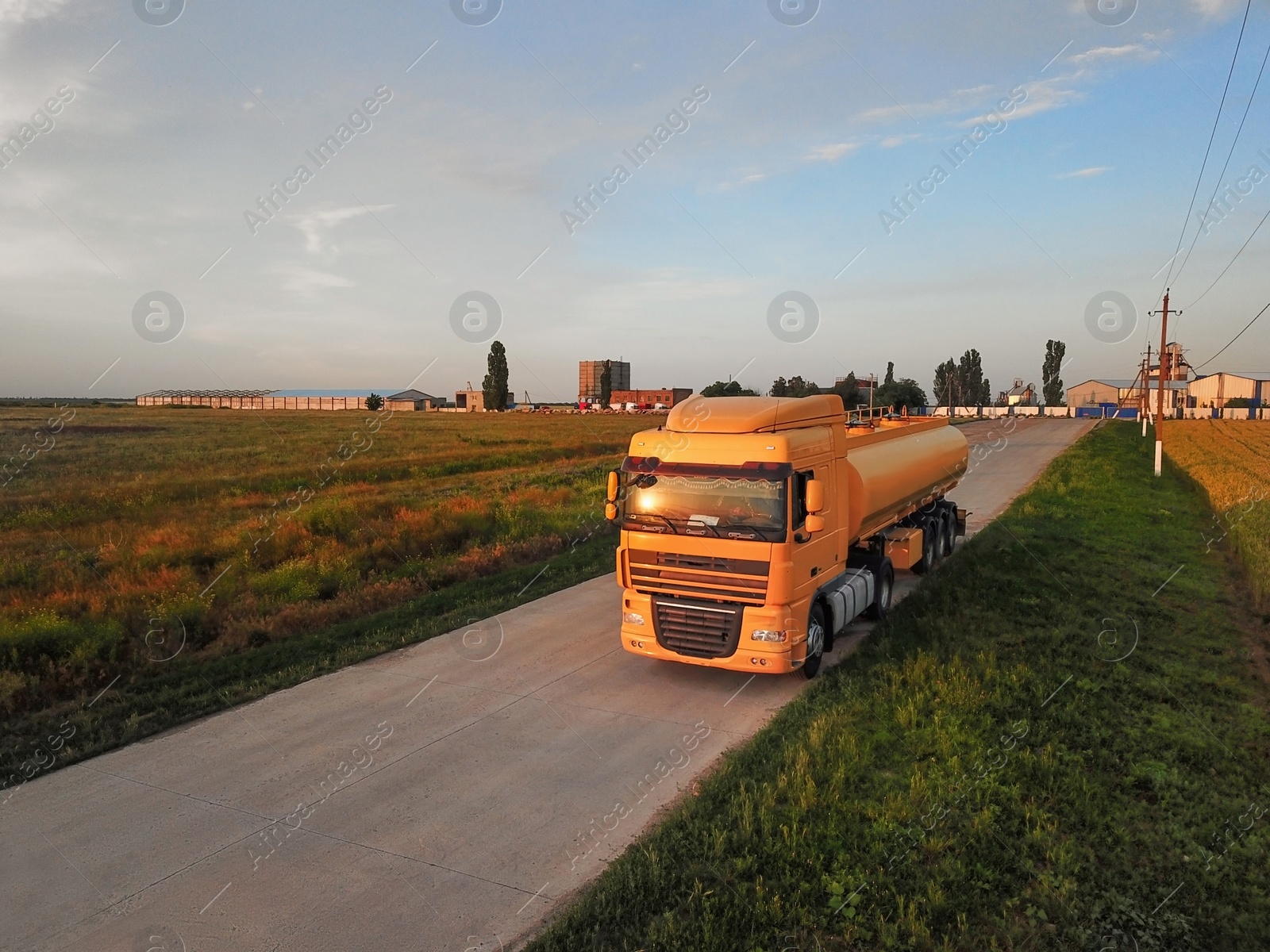 Photo of Modern yellow truck on country road. Space for text