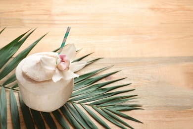 Photo of Composition with fresh coconut drink in nut on wooden background