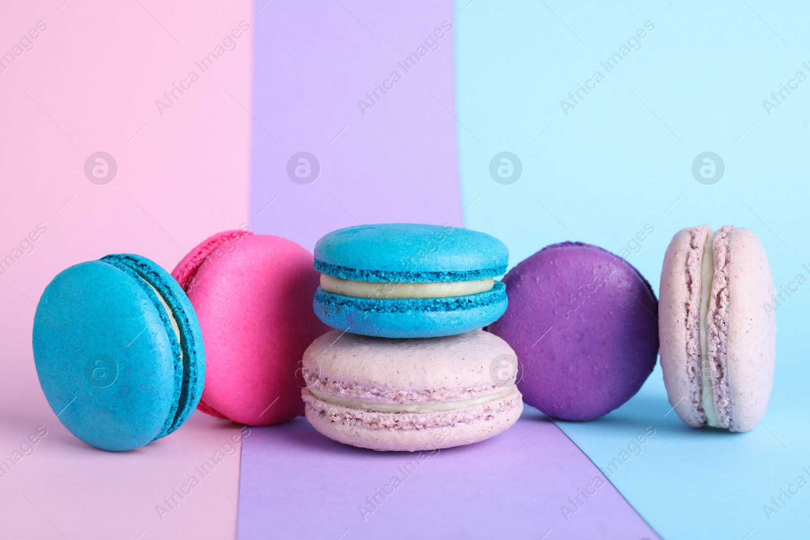 Photo of Different delicious fresh macarons on color background