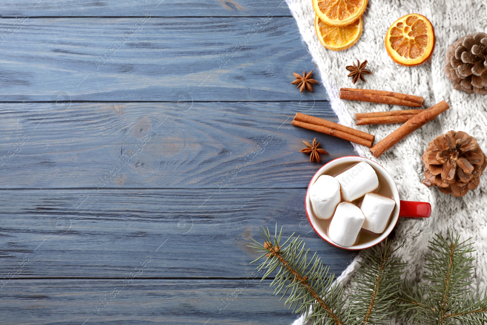 Photo of Flat lay composition of tasty cocoa with marshmallows on blue wooden table. Space for text