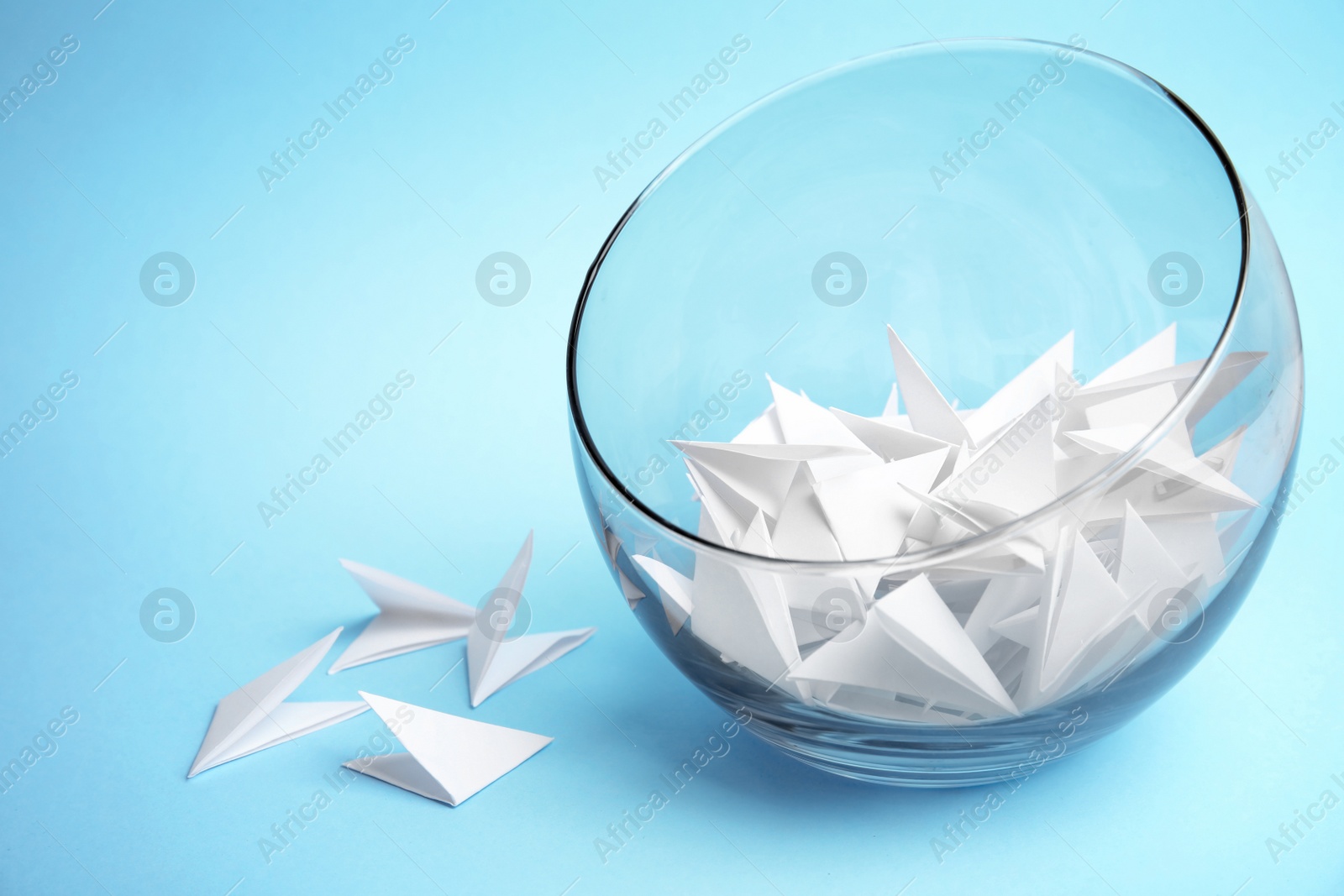 Photo of Paper pieces for lottery in glass vase on color background. Space for text