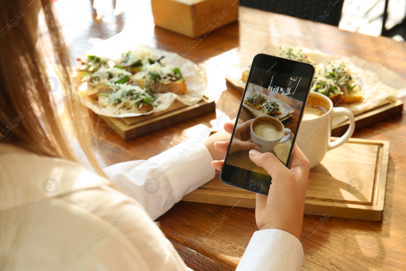 Photo of Food blogger taking photo of her lunch at cafe, closeup