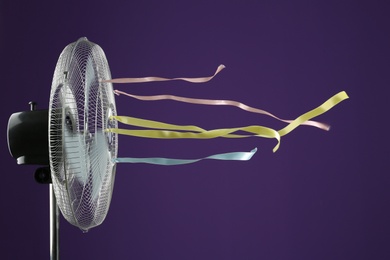 Photo of Electric fan on purple background. Summer heat