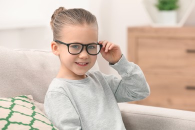 Photo of Portrait of smiling little girl wearing glasses indoors