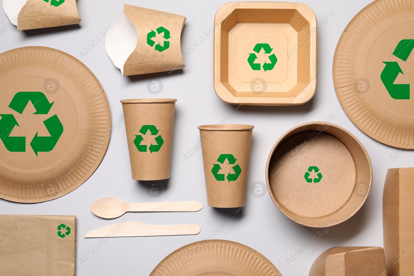 Image of Set of eco friendly food packaging with recycling symbols on light background, flat lay