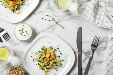 Photo of Delicious fresh carrot salads served on white marble table, flat lay