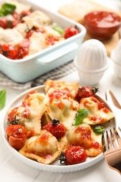 Photo of Tasty ravioli with tomato sauce served on white table