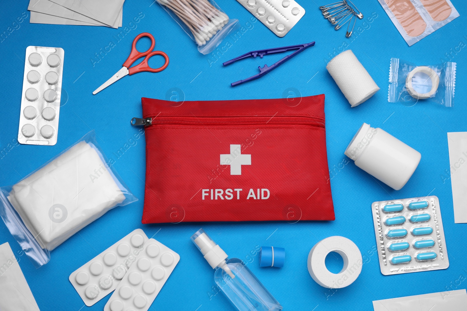 Photo of Flat lay composition with first aid kit on light blue background