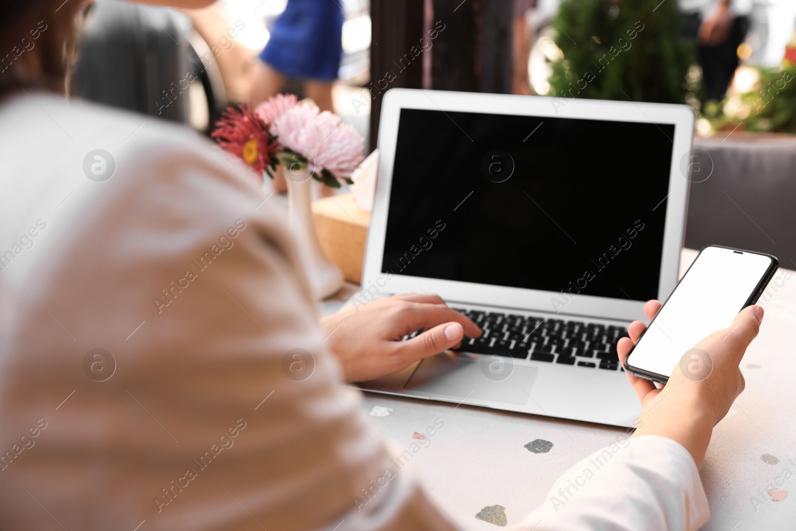 Photo of Woman using smartphone at table in outdoor cafe, closeup