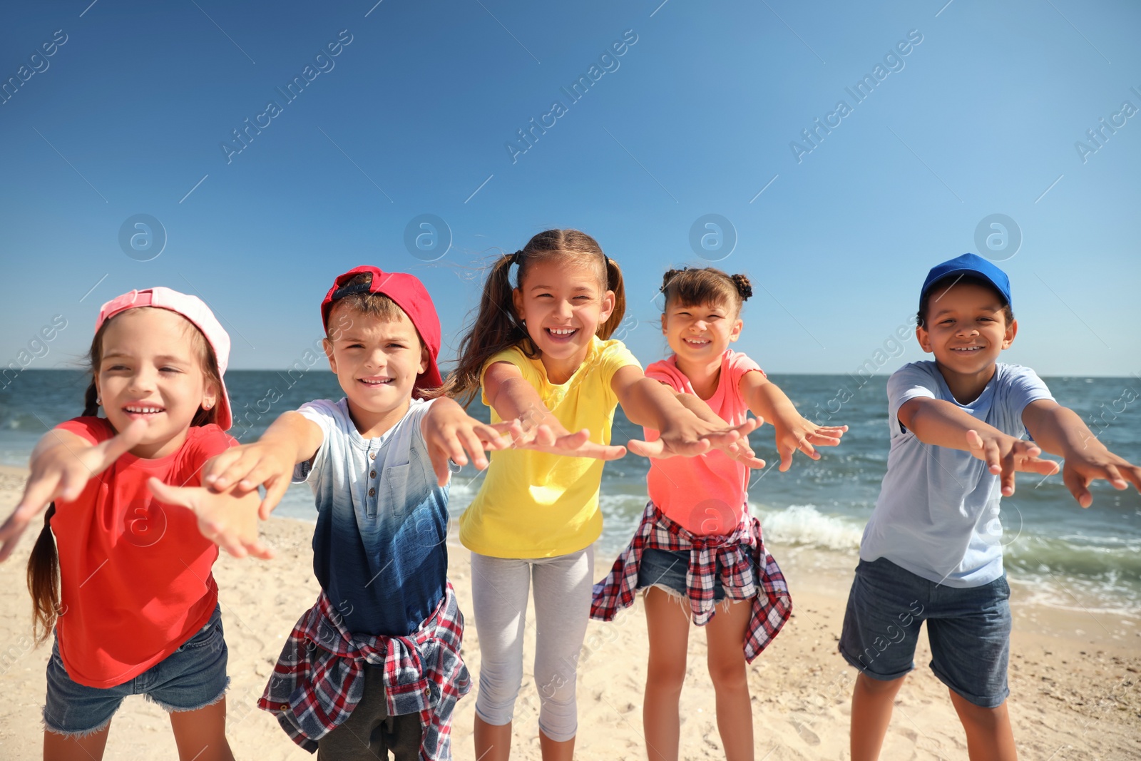 Photo of Group of happy children at sea beach on sunny day. Summer camp