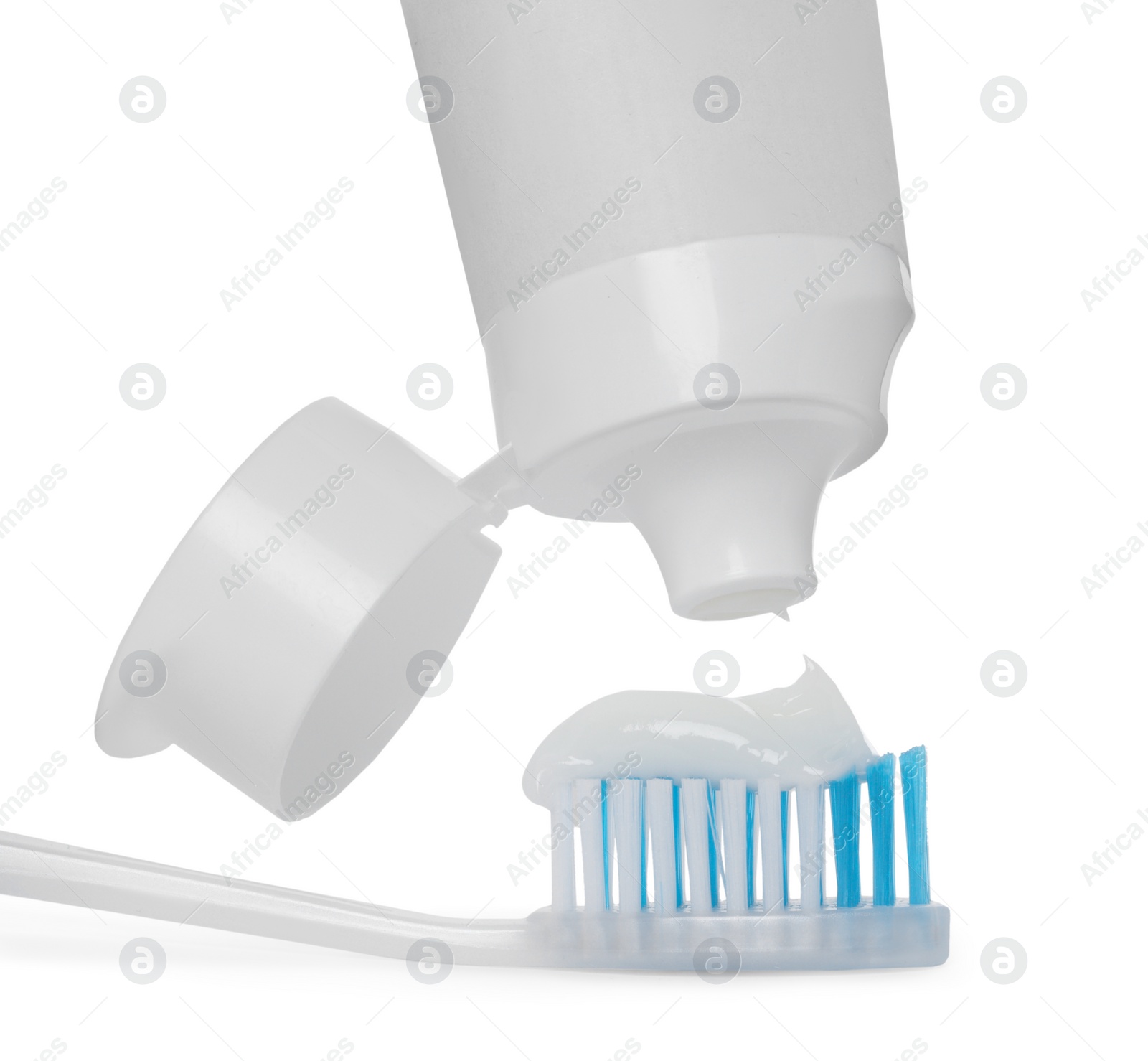 Photo of Applying paste on toothbrush against white background, closeup