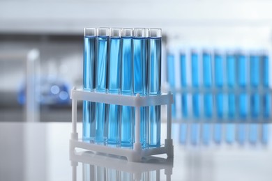 Test tubes with light blue liquid on table in laboratory
