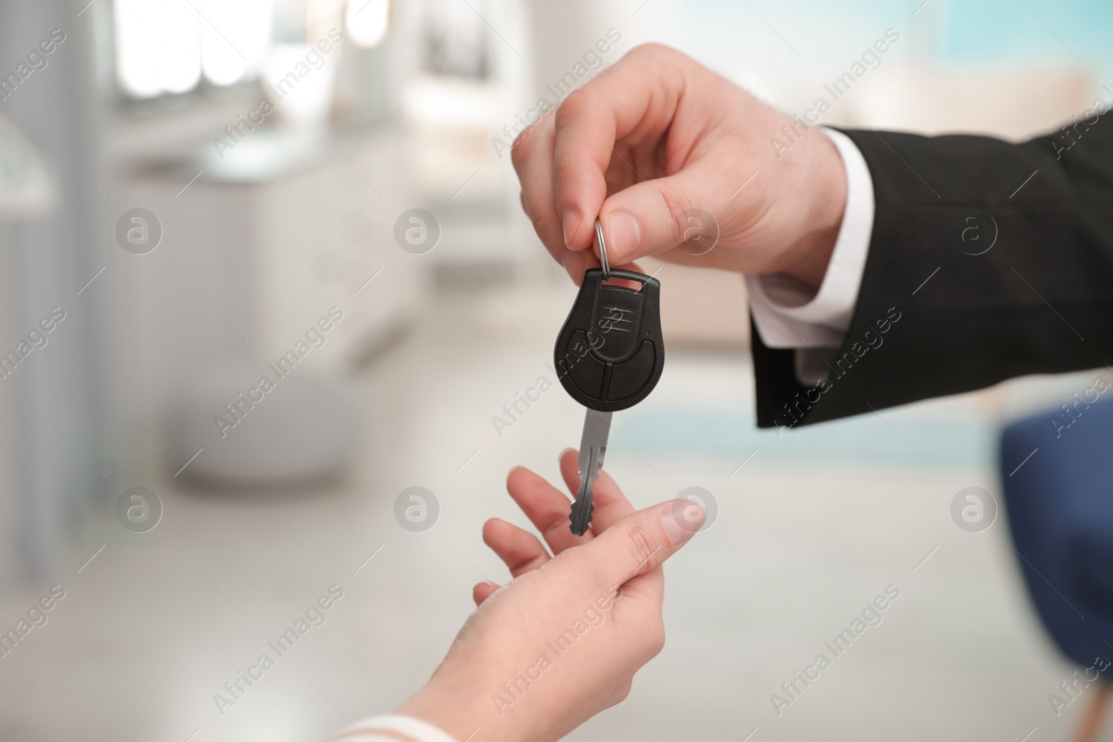 Photo of Man giving car key to woman indoors, closeup. Space for text