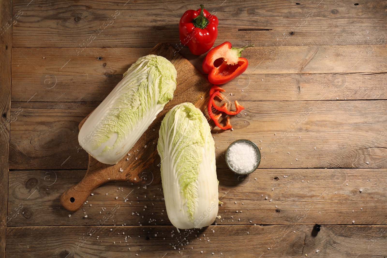 Photo of Fresh Chinese cabbages, bell peppers and salt on wooden table, flat lay. Space for text