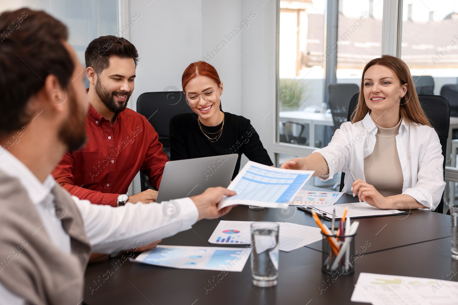 Photo of Team of employees working together in office