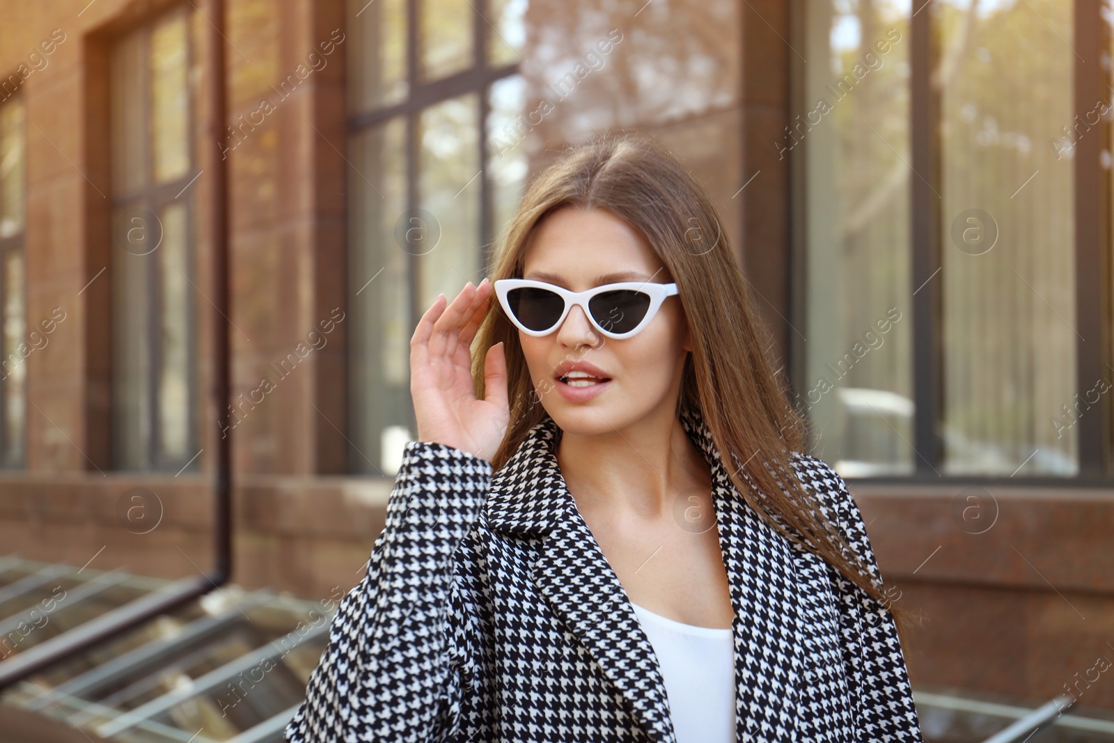 Photo of Young woman wearing stylish sunglasses on city street