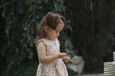 Photo of Cute little girl in green park, space for text