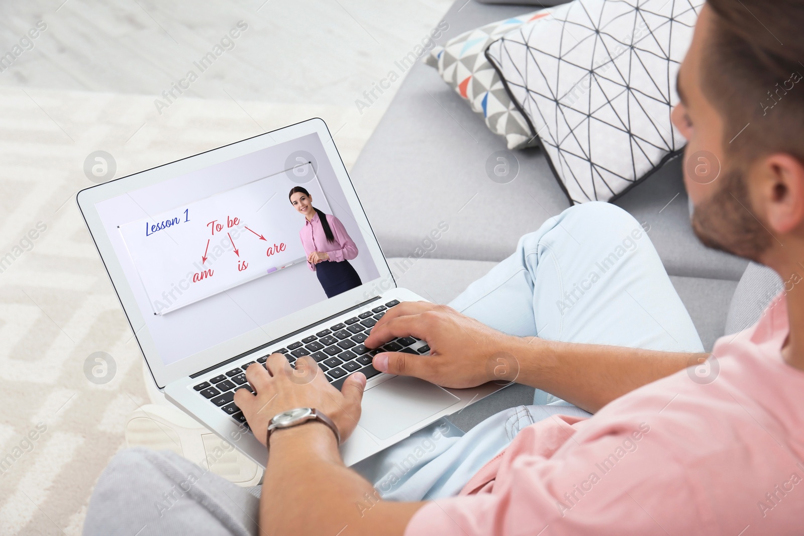 Image of Young man using laptop for online English lesson with teacher at home, closeup