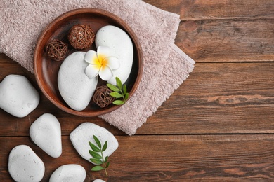 Photo of Flat lay composition with spa stones and space for text on wooden background