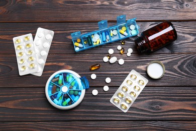Photo of Pill boxes with medicaments on wooden table, flat lay