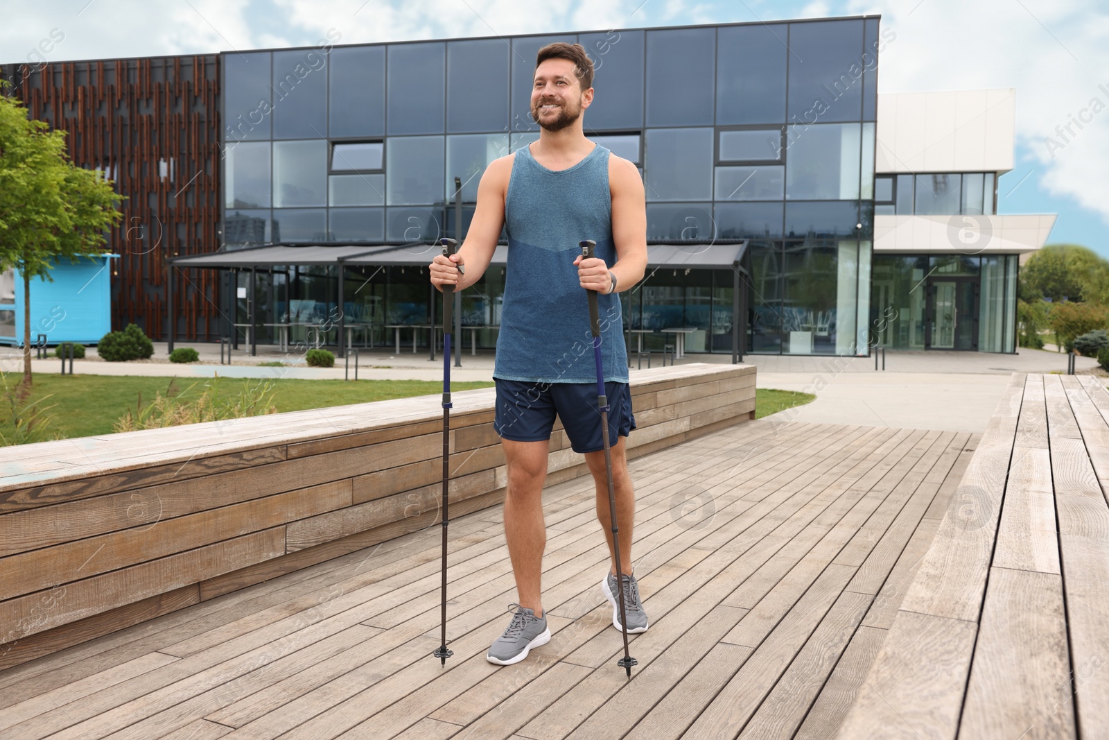 Photo of Man practicing Nordic walking with poles outdoors