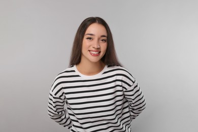 Photo of Portrait of beautiful young woman on light grey background