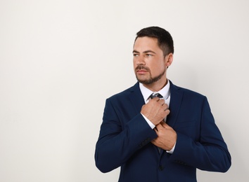 Portrait of handsome man in suit on light background. Space for text