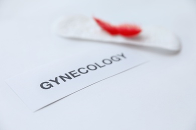 Photo of Card with word GYNECOLOGY on light background, closeup