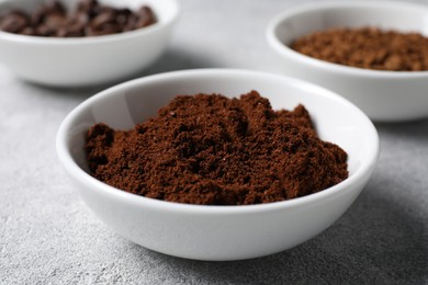 Bowl with ground coffee on light grey table, closeup